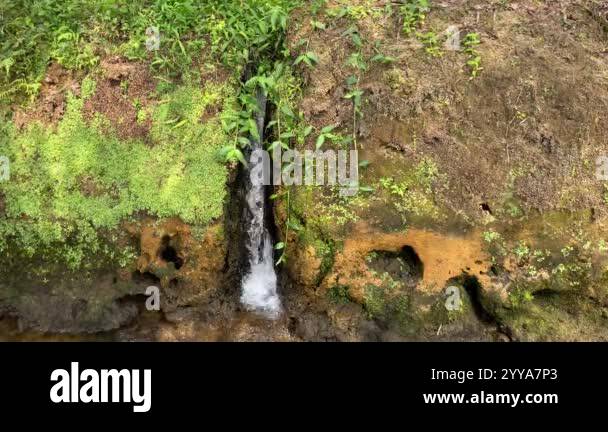 Mini waterfall from the water conduit to the river. Water flowing from ...