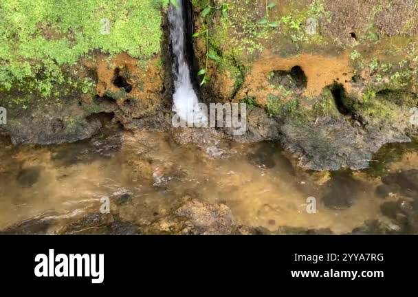Mini waterfall from the water conduit to the river. Water flowing from ...