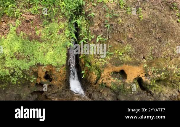 Mini waterfall from the water conduit to the river. Water flowing from ...