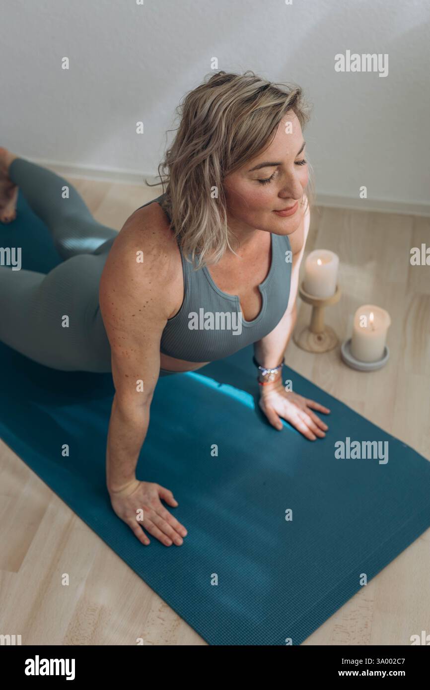 A 50-year-old woman does yoga at home Stock Photo - Alamy