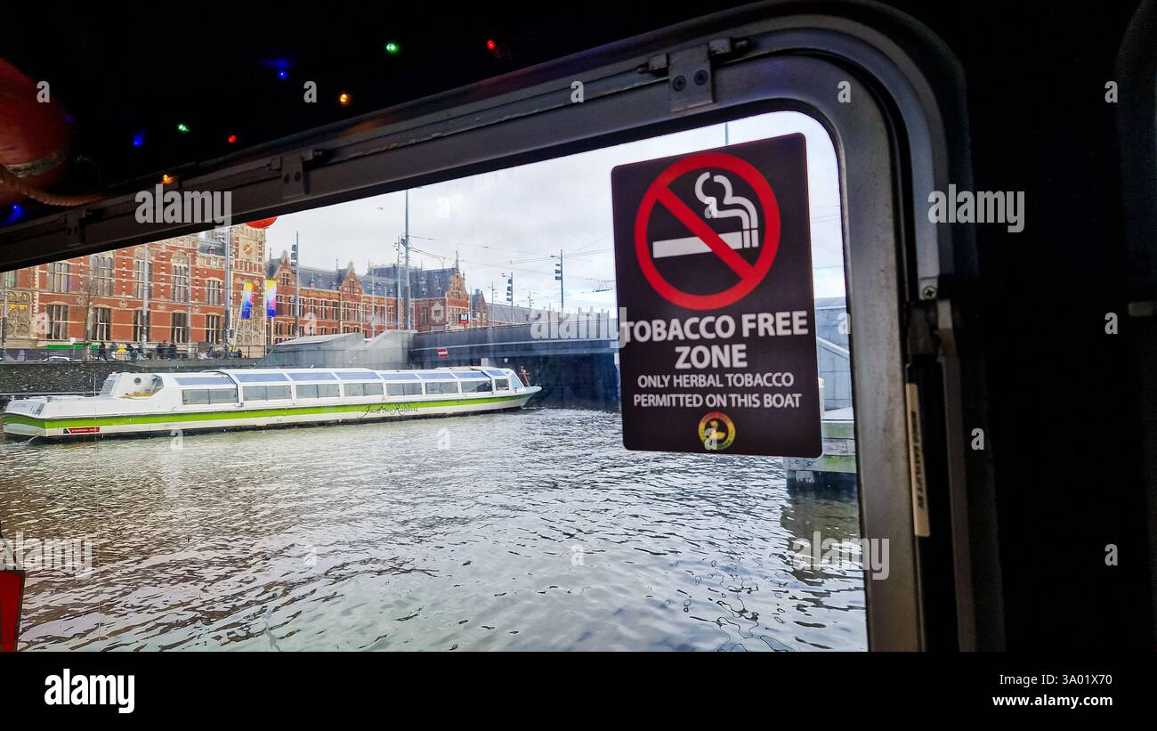 Amsterdam, Netherlands - December 3,  2024: Sign with text 'Tobacco free zone. Only herbal tobacco permitted on this boat.' - Smartphone Captured Stock Image