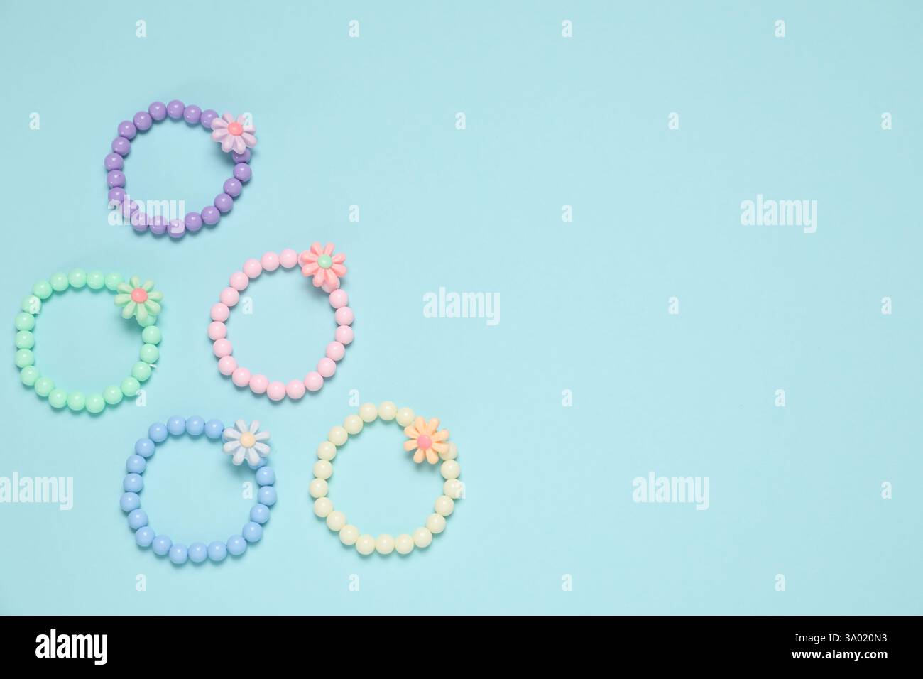Different hair ties on light blue background, flat lay. Space for text Stock Photo