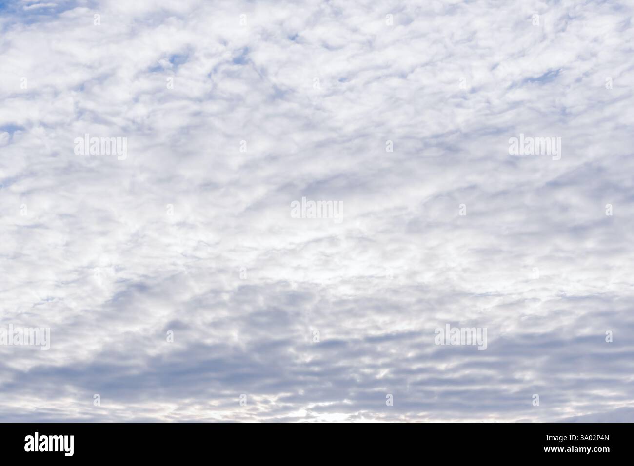 A soft and textured sky filled with gentle, subtle cloud formations, evoking a profound sense of tranquility and calm. Uniform grey clouds background Stock Photo