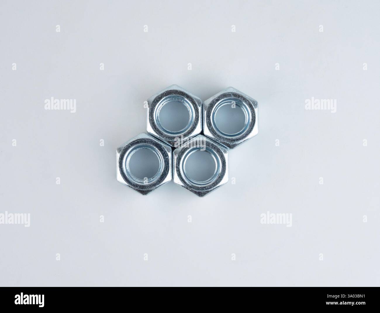 Metal nuts arranged in a geometric pattern Stock Photo