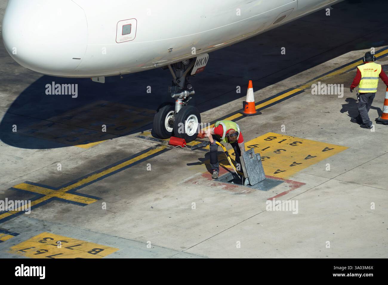 Airport ground crew preparing parked airplane for departure. Stock Photo