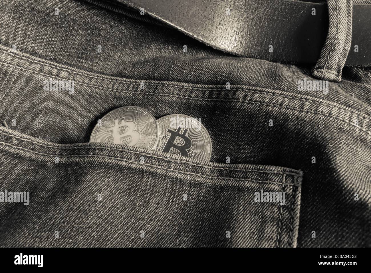 Two Bitcoin physical coins inside a blue jeans pocket Stock Photo