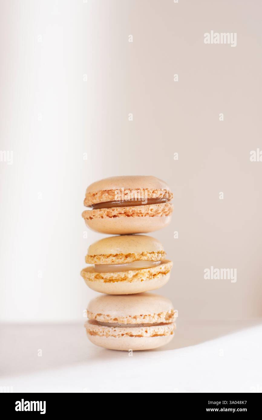 Three soft beige pastel macarons stacked Stock Photo
