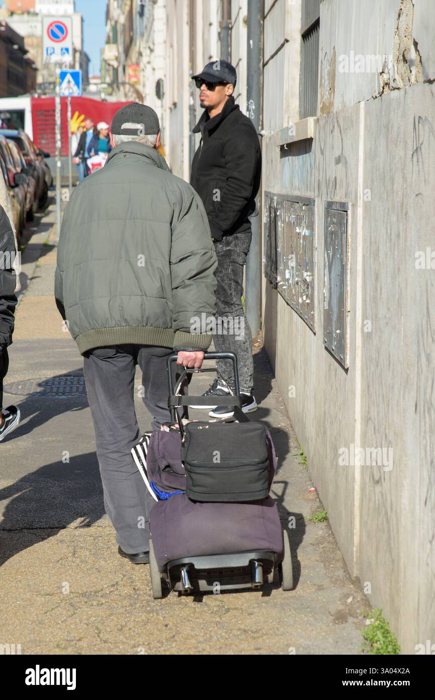 March 2, 2025, Rome, Italy: An elderly man drags a trolley with his ...