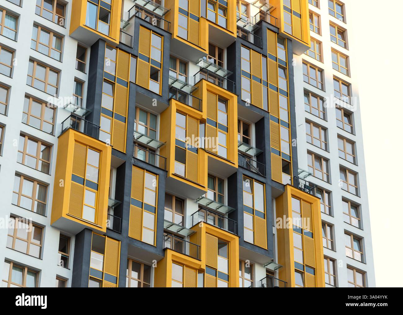 Modern high-rise residential building with bright yellow balconies in ...