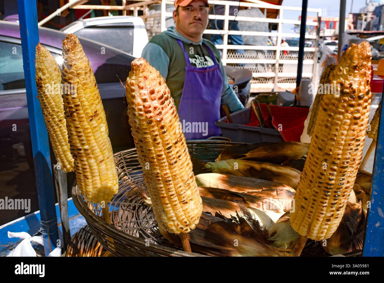 Male vendor sells roasted corn on a stick in Nuevo Progreso, Mexico. Stock Photo