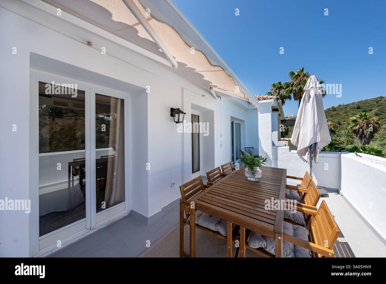 Image showcasing an image of a luxury balcony terrace with large wooden outdoor dining ...