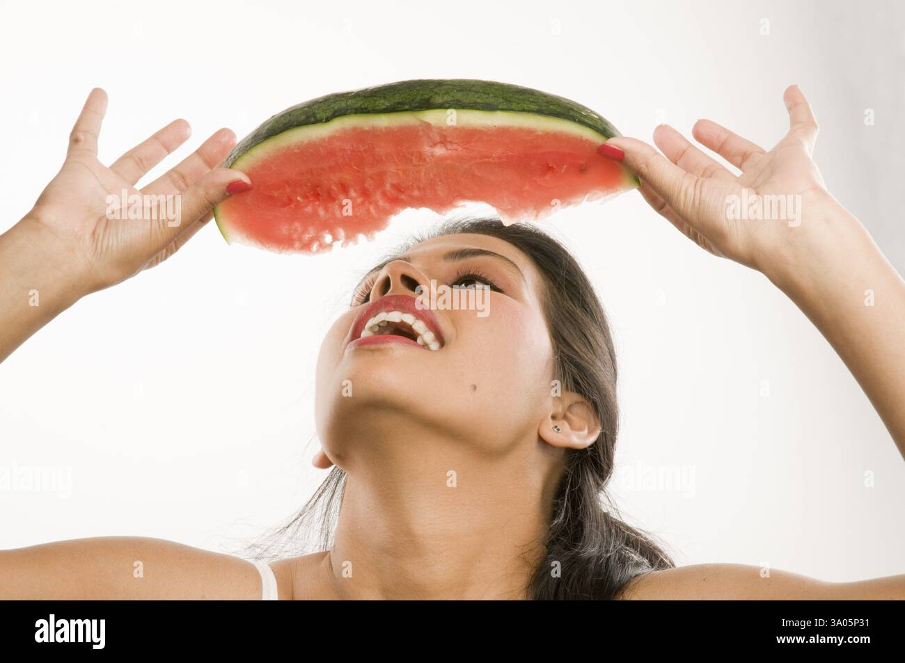 Lady stretching head eat Watermelon Pune Maharashtra India Asia Jan 2011 MR#686 W Stock Photo