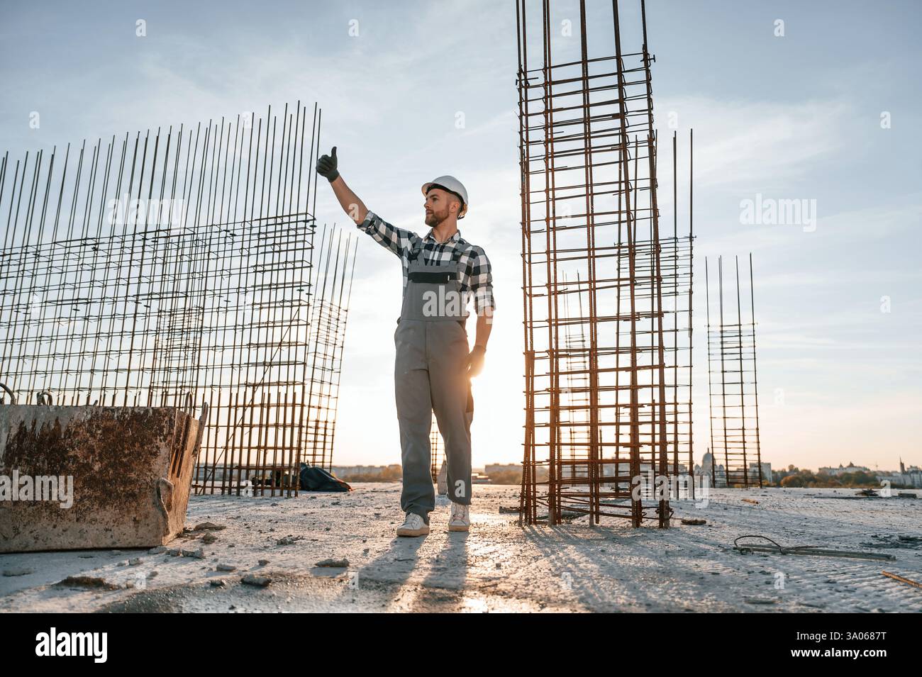 On construction site. Man in grey uniform is working. Stock Photo