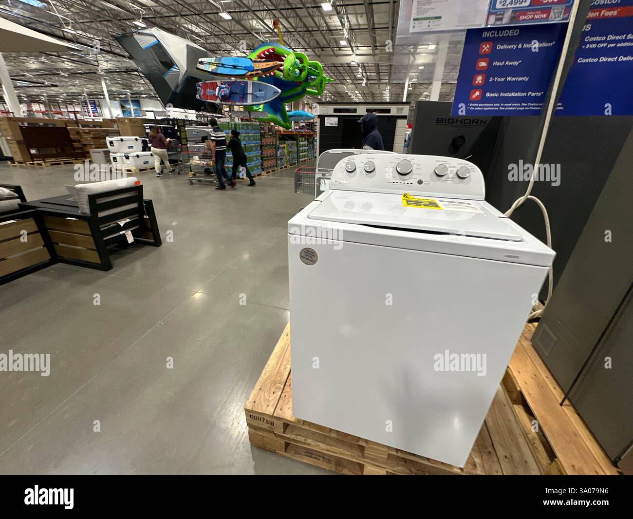 A washer sits on display as shoppers pass by in a Costco warehouse ...