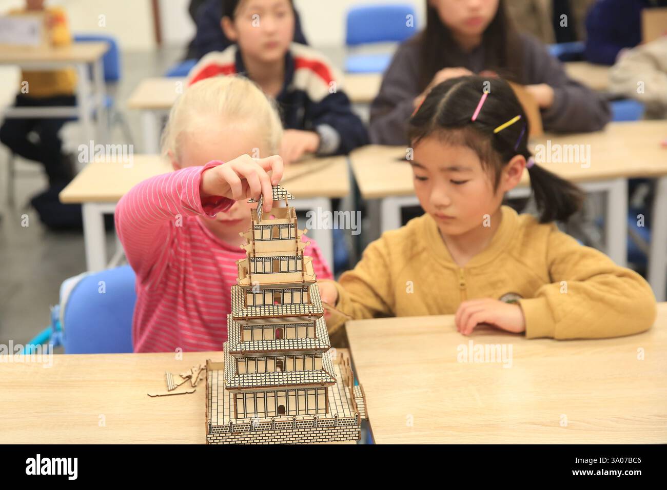 (250303) -- LUQA, March 3, 2025 (Xinhua) -- Two girls build a model of
