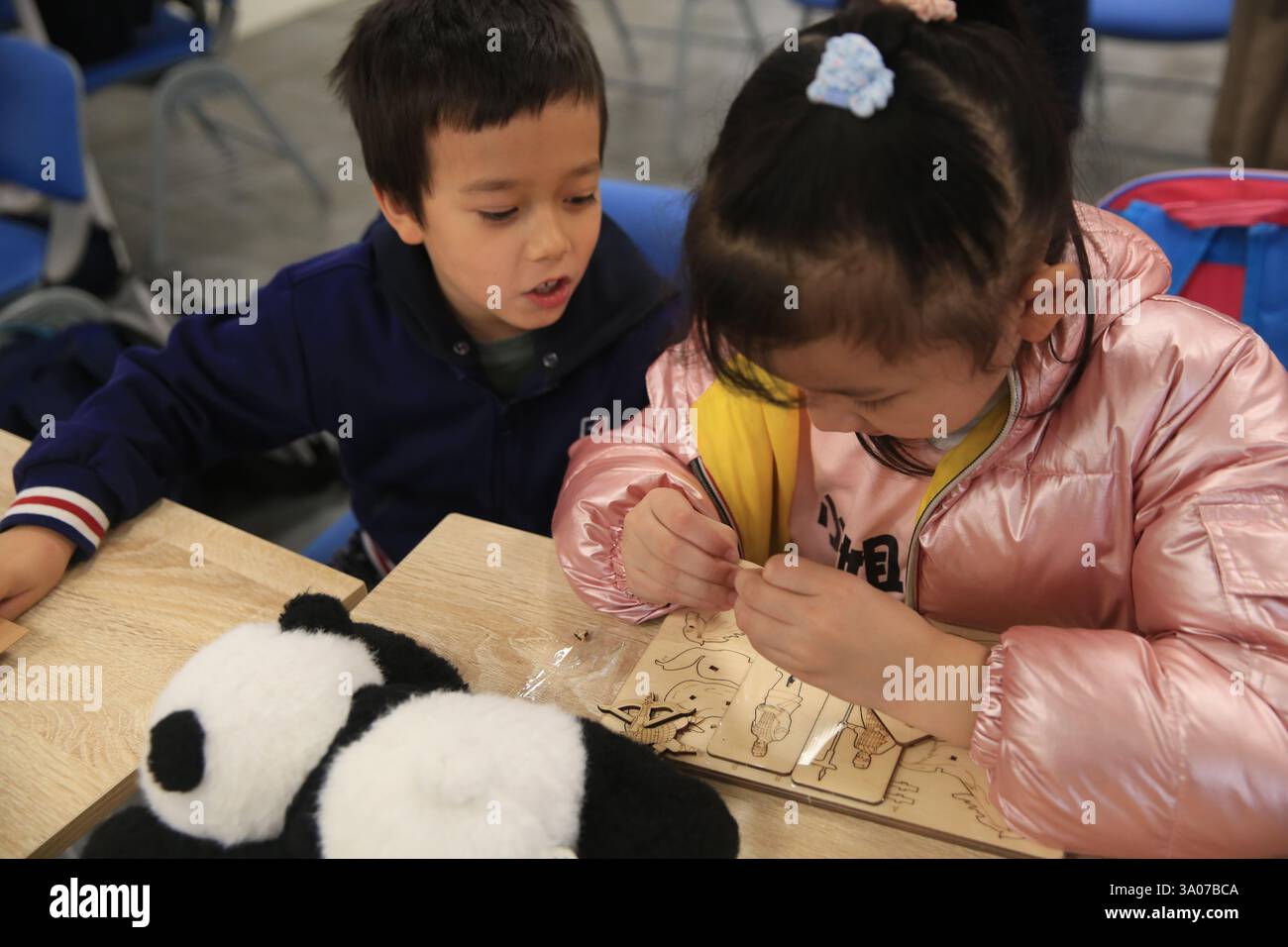 (250303) -- LUQA, March 3, 2025 (Xinhua) -- A boy and a girl solve a
