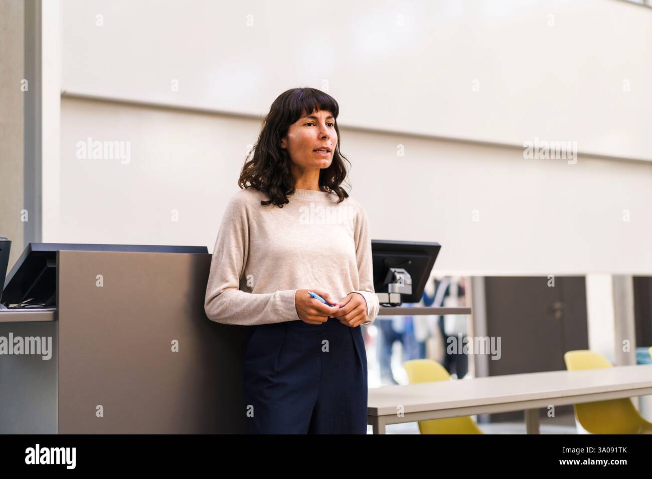 Confident female teacher explaining while standing in lecture hall at university Stock Photo