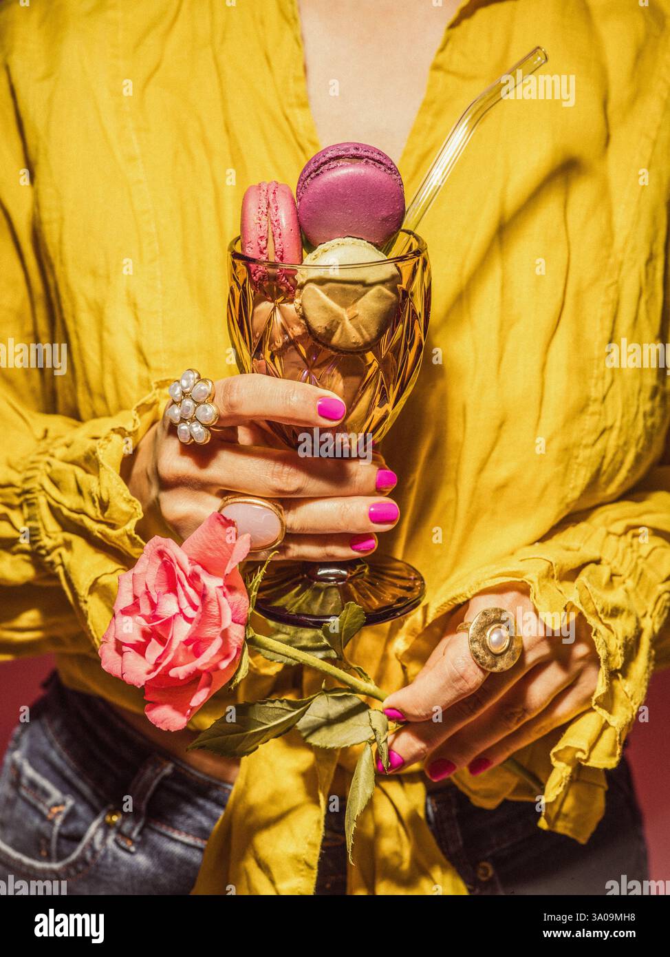 Woman holding a glass with macaroons Stock Photo