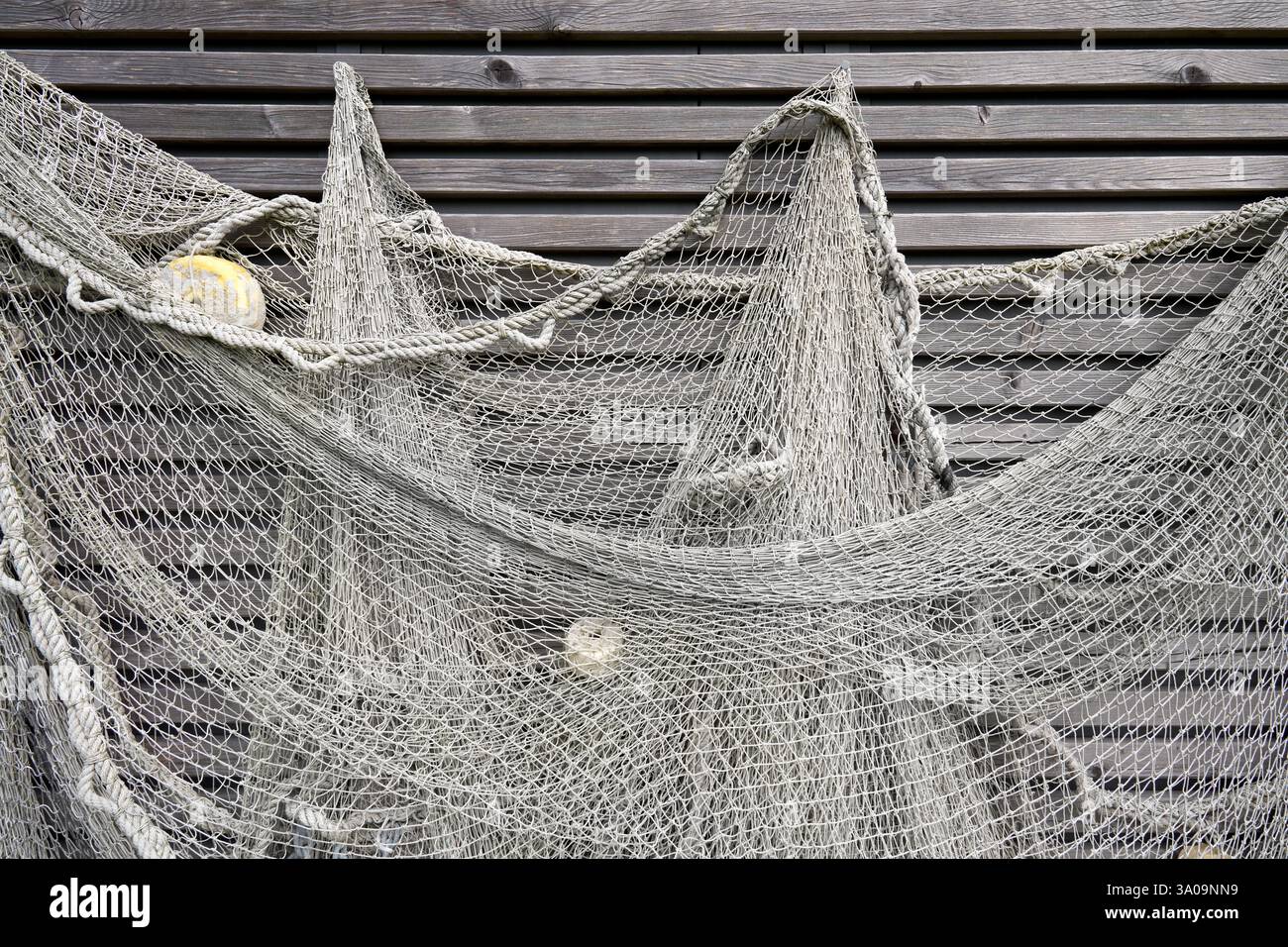 Gray fishing net hanging on a wall with wooden slats Stock Photo - Alamy