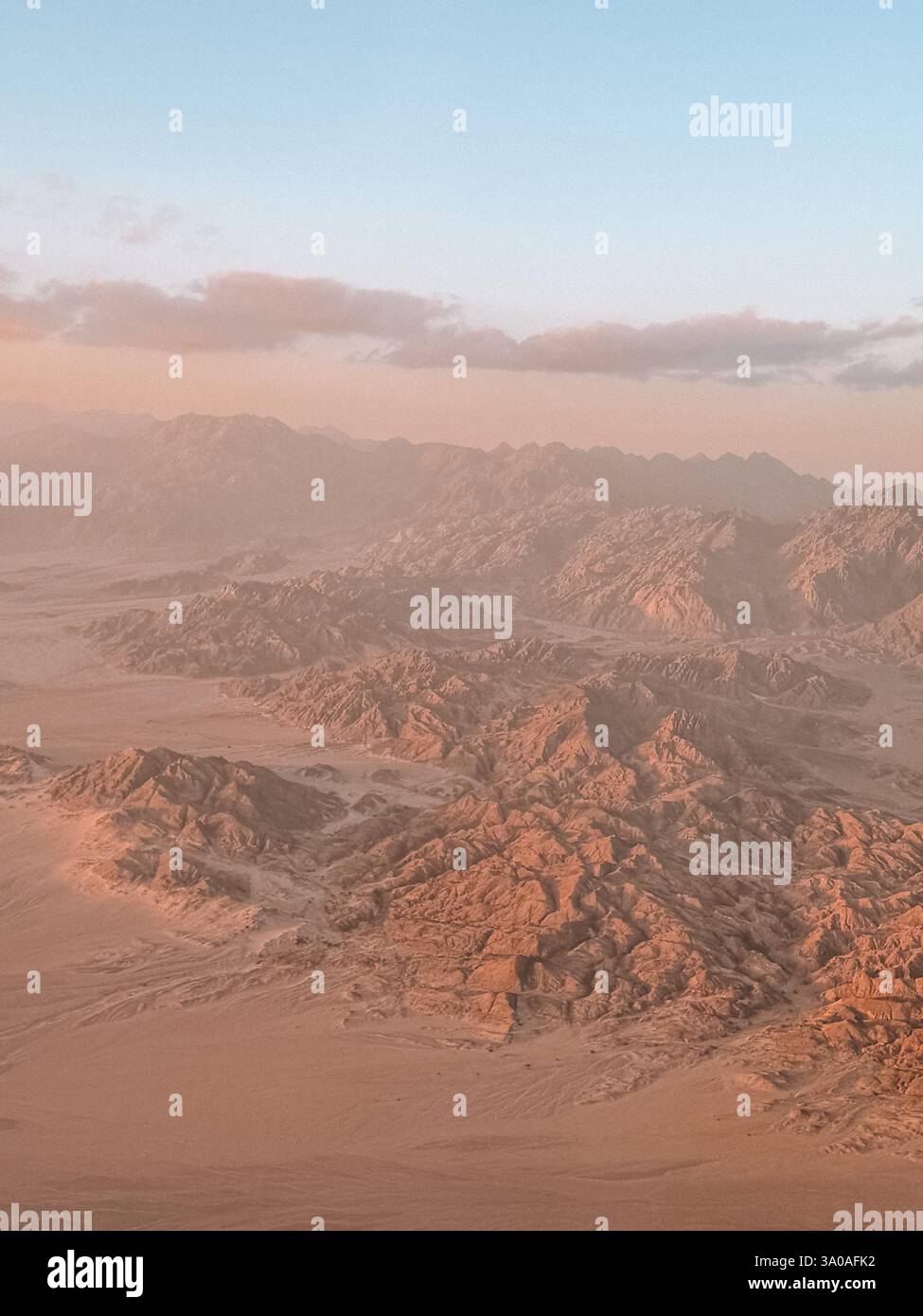 A breathtaking photo of the Sinai Mountains in Egypt at sunset, with rugged peaks bathed in warm golden light. - Smartphone Captured Stock Image