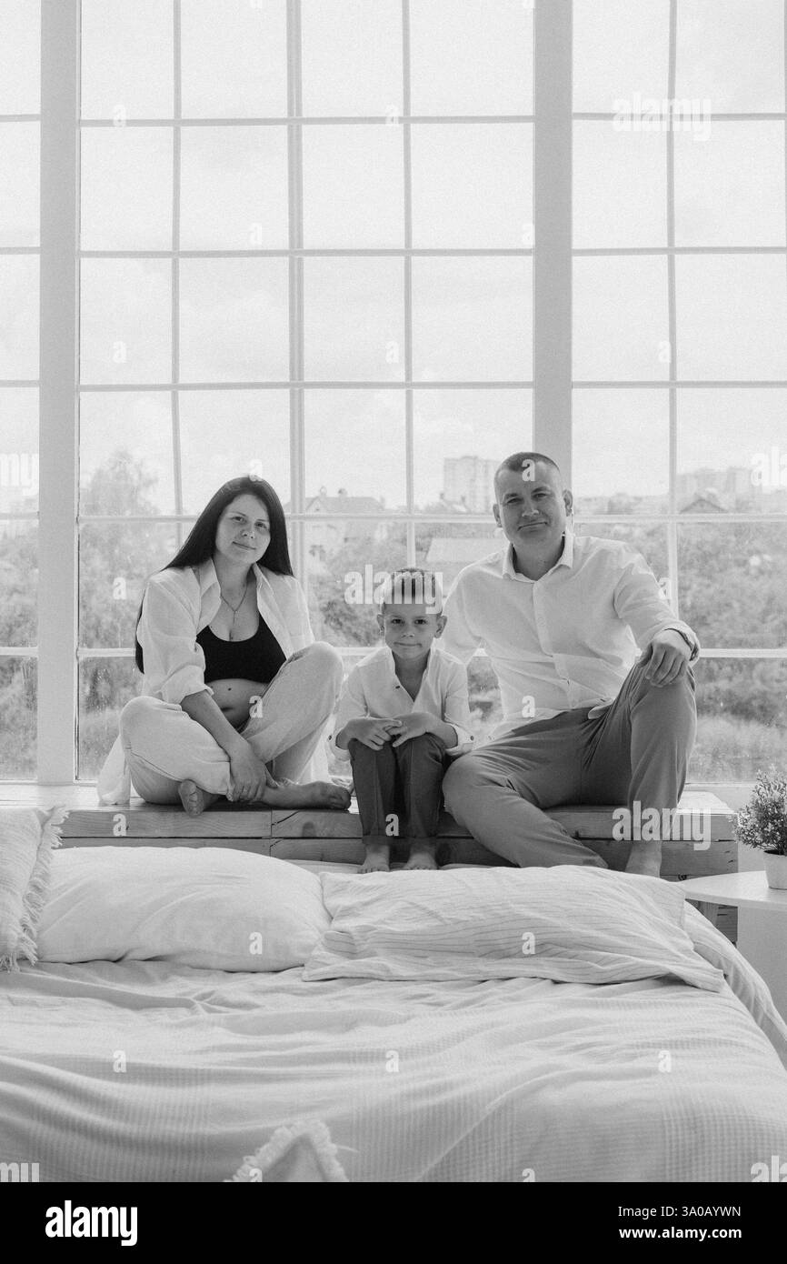 Family pregnancy photoshoot with father, pregnant mother, and son Stock Photo