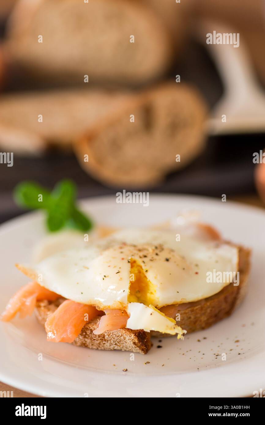 A slice of bread with a cooked egg and lightly salted red fish. Stock Photo