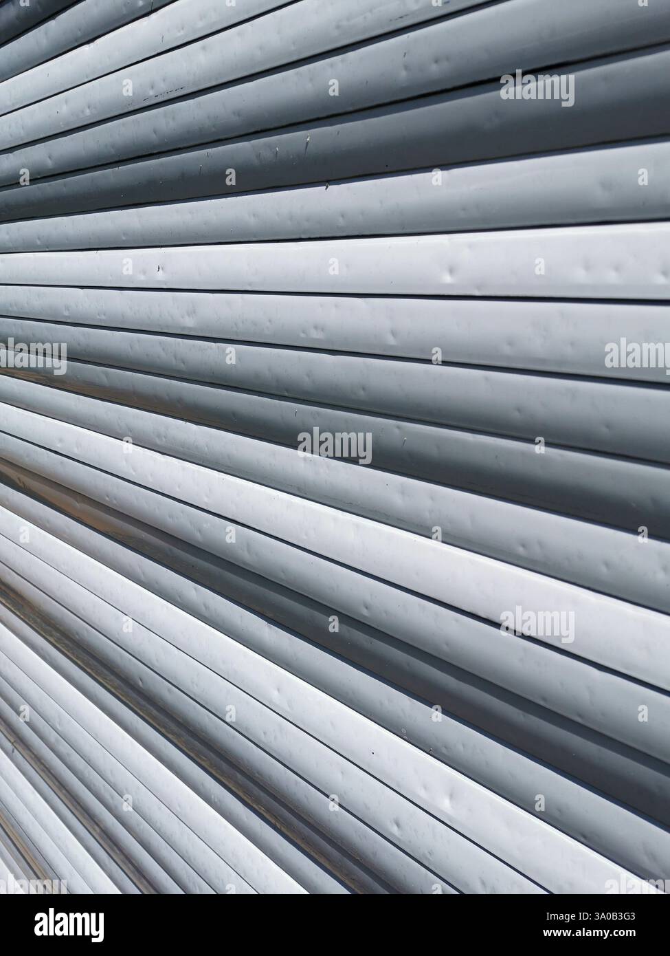 Hail marks create texture on metal roller shutter  after severe weather event - Smartphone Captured Stock Image