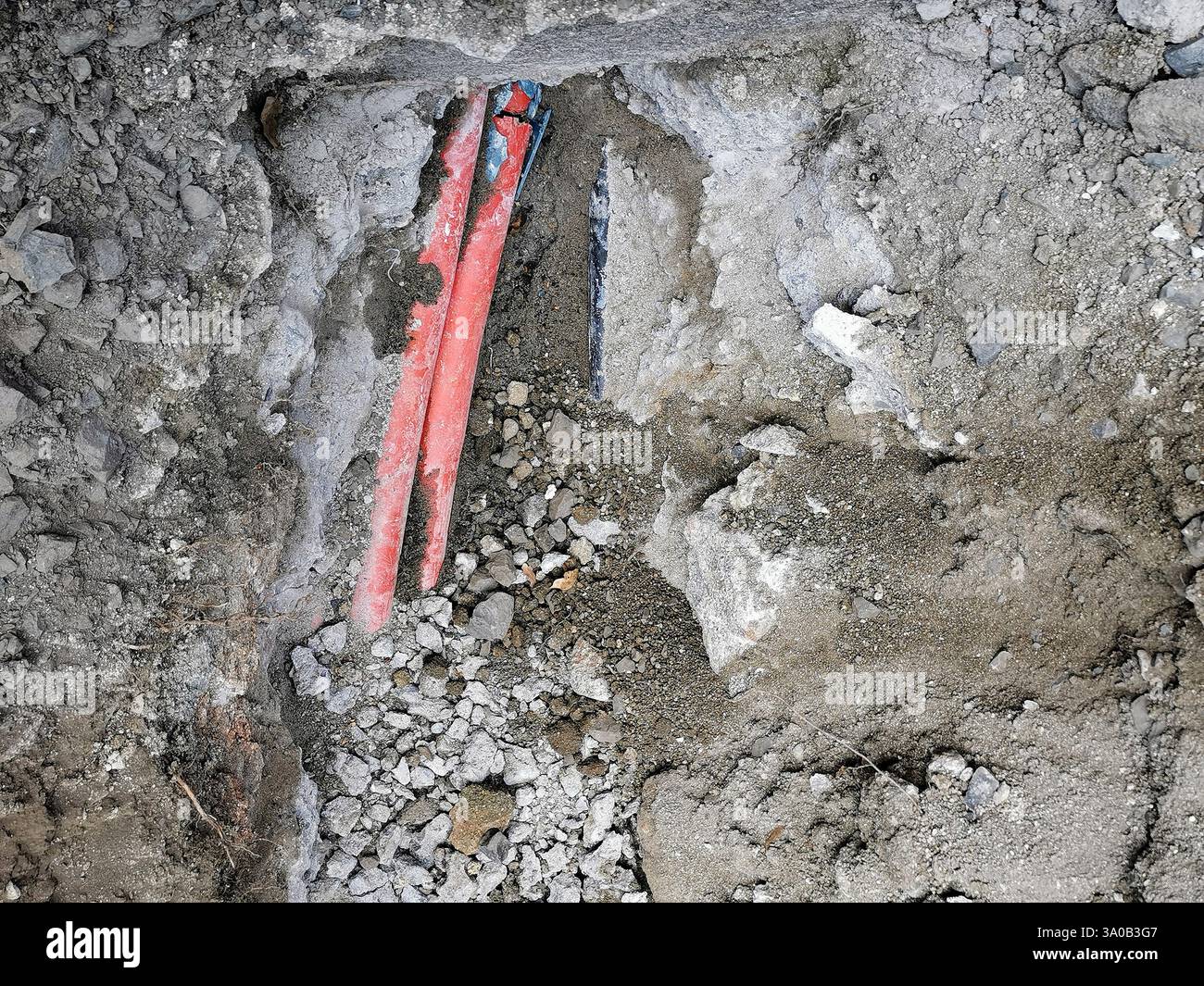 Utility lines exposed during excavation in a construction site revealing red and blue cables - Smartphone Captured Stock Image