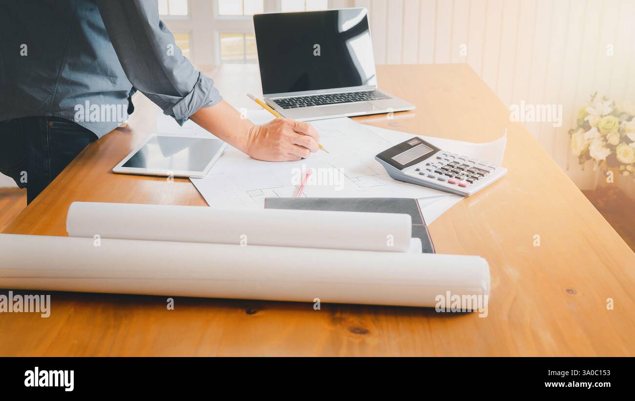 An architect or engineer writing on blueprint, architectural concept. Stock Photo