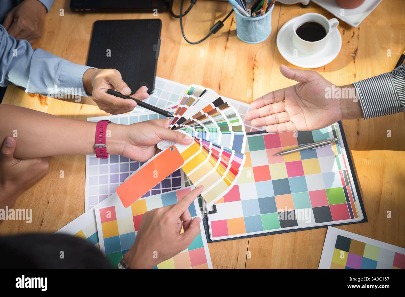 Interior designer chooses a color chart for home design. Graphic designers working on color chart at modern office. Stock Photo