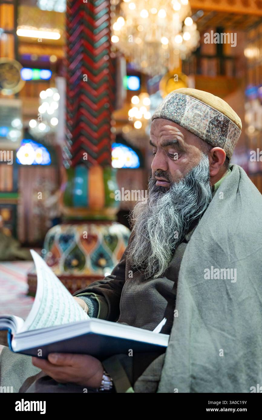 A Kashmiri Muslim man recites from the Islamic book Quran inside a ...