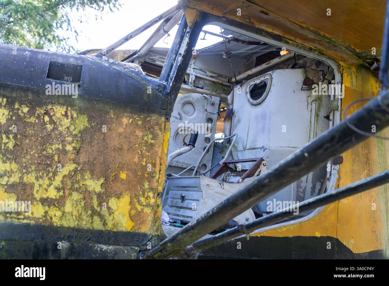 Disassembled cockpit of an old yellow abandoned wrecked airplane Stock Photo