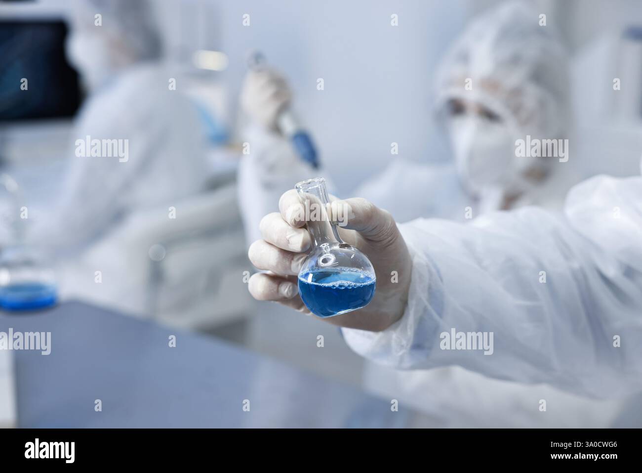 Scientist holding flask with blue sample in laboratory, closeup Stock ...