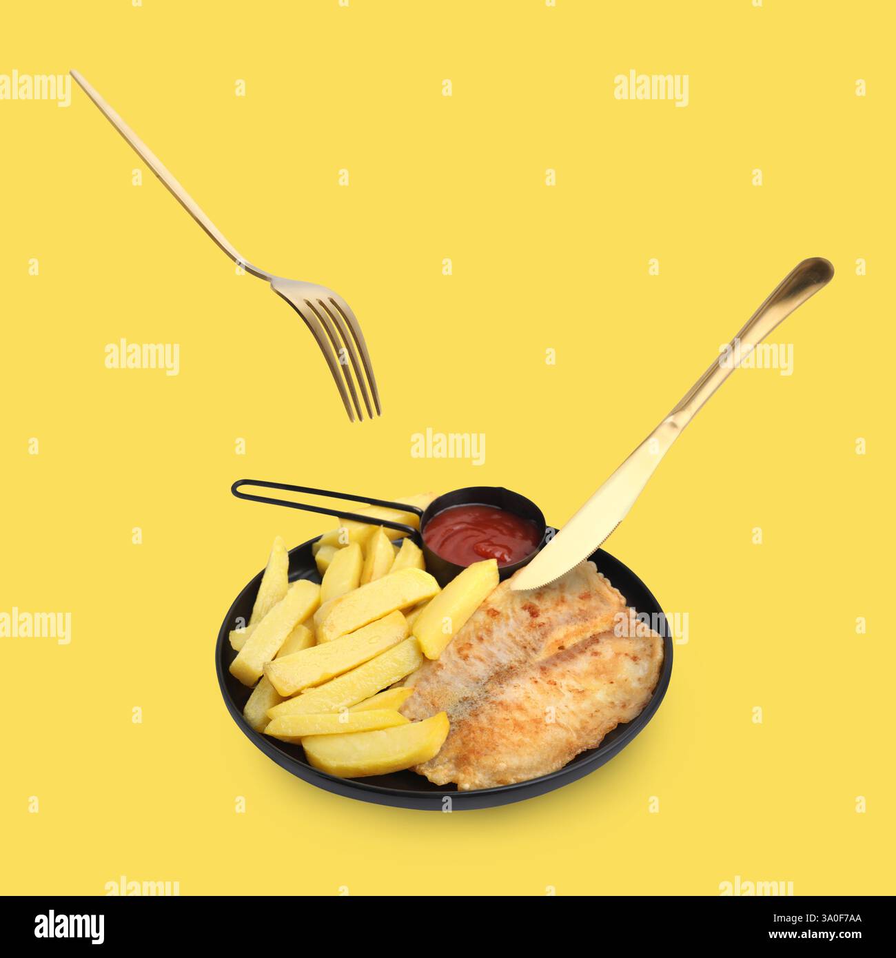 Cutlery in air over plate with delicious fish and chips on pastel yellow background Stock Photo