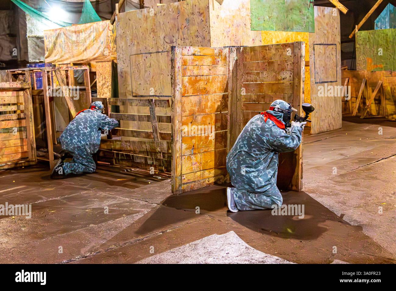 indoor paintball - attacking the enemy from cover, selective focus Stock Photo