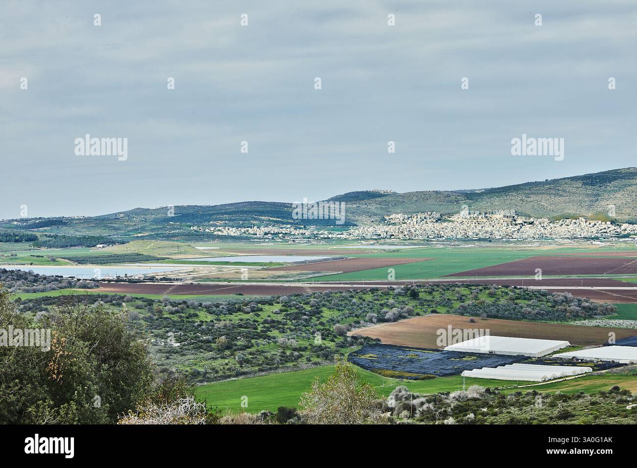 A vast rural landscape with cultivated fields, patches of greenery, and ...