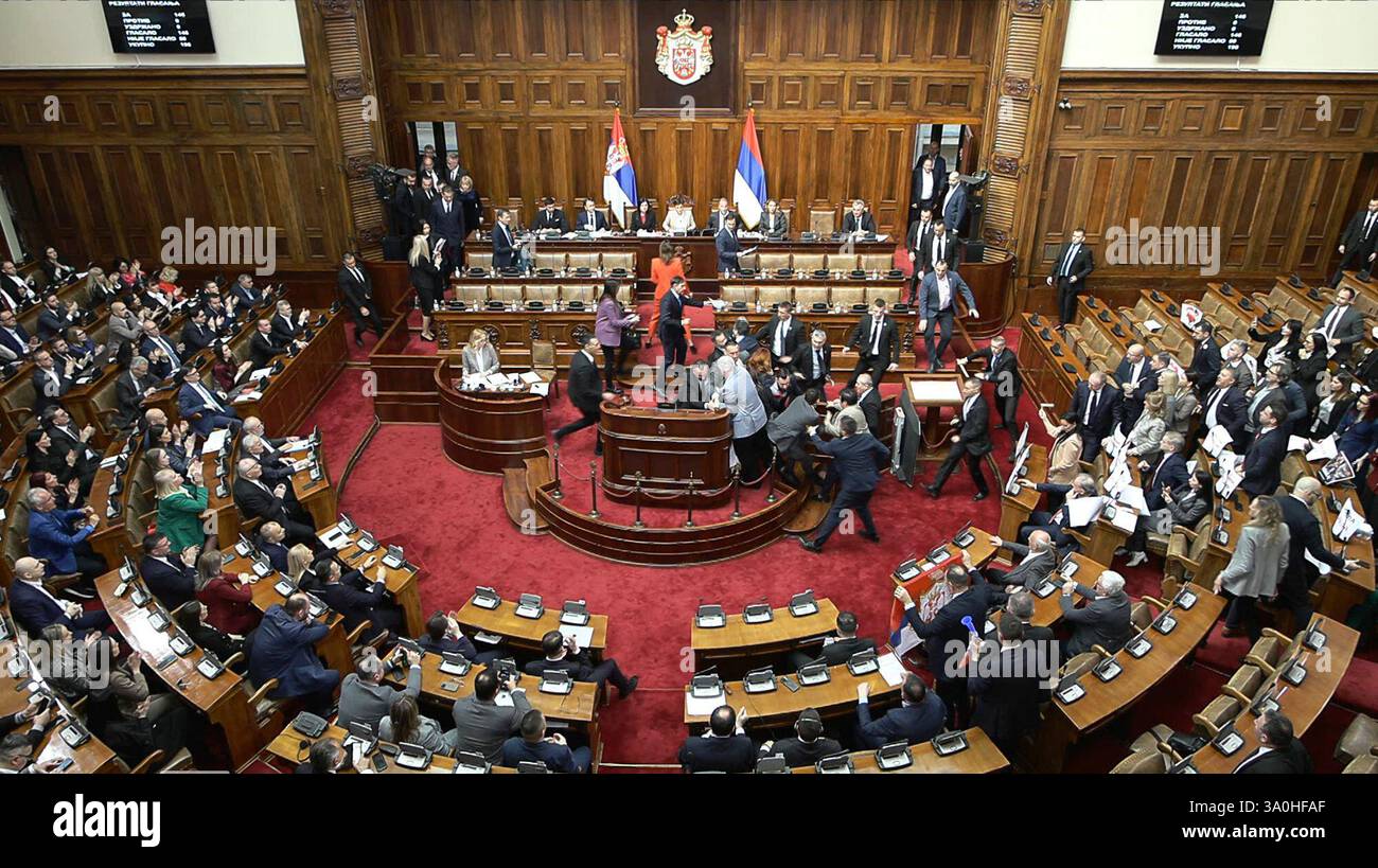 In this grab taken from video provided by RTS Serbia, lawmakers scuffle ...