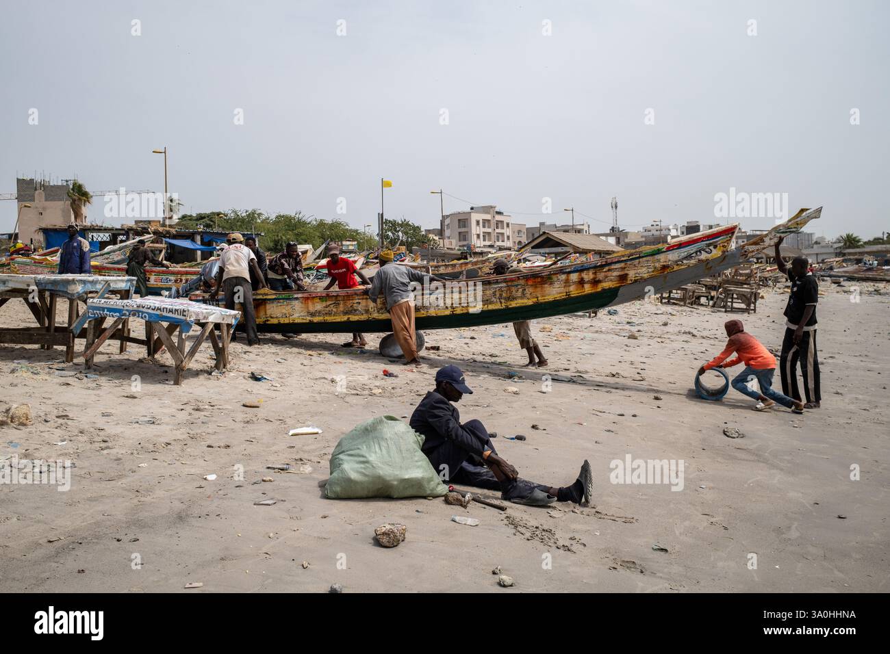 Fishermen pull a pirogue onto Soumbedioune beach in Dakar, February 12