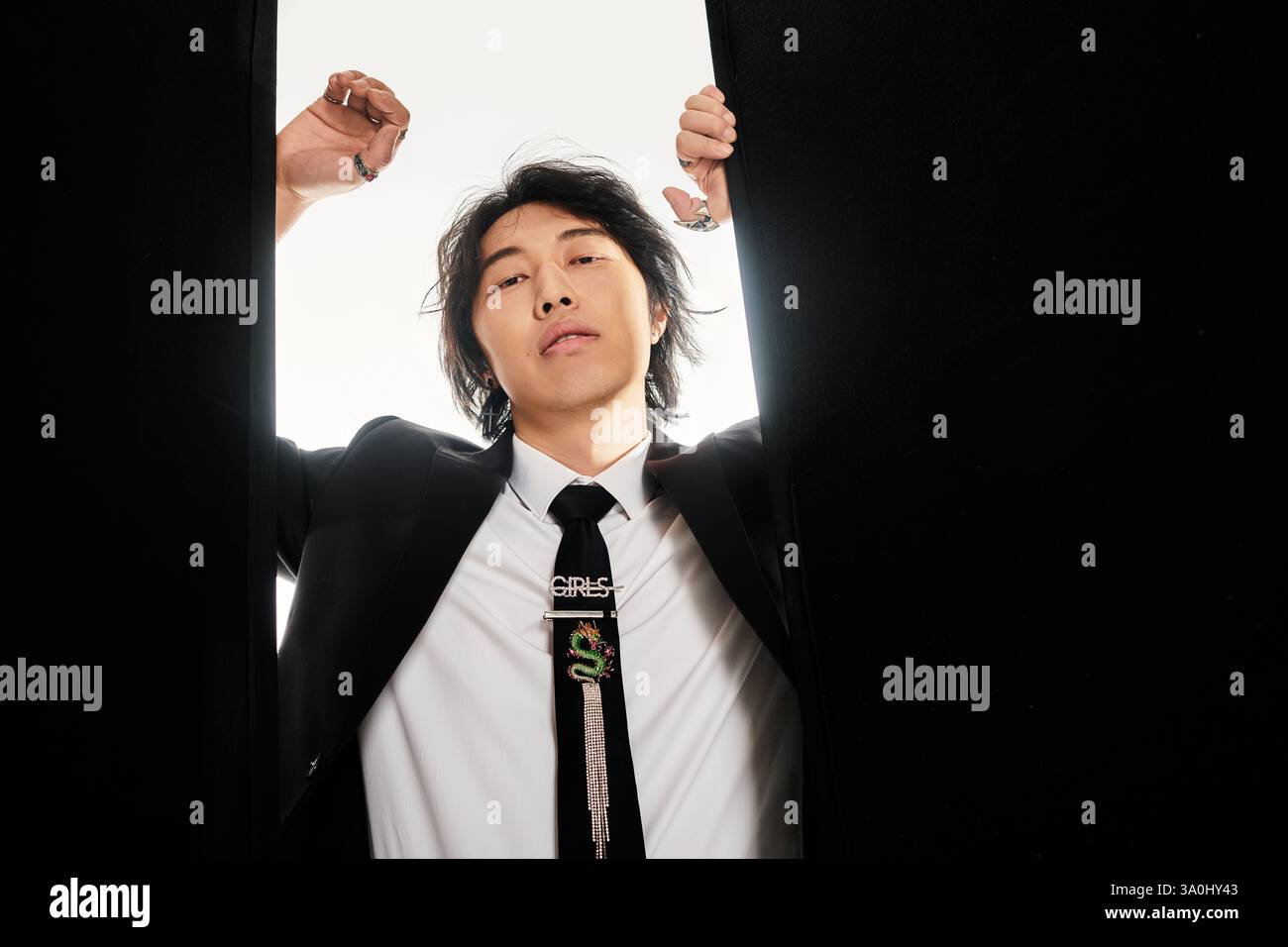 A stylish young man poses confidently, embodying urban flair and ...
