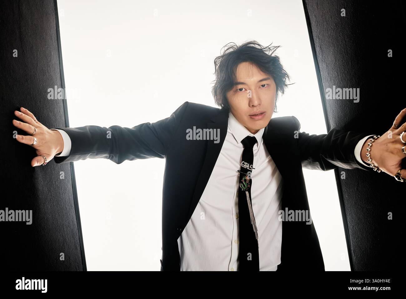 A stylish young man confidently poses in a modern outfit against a ...