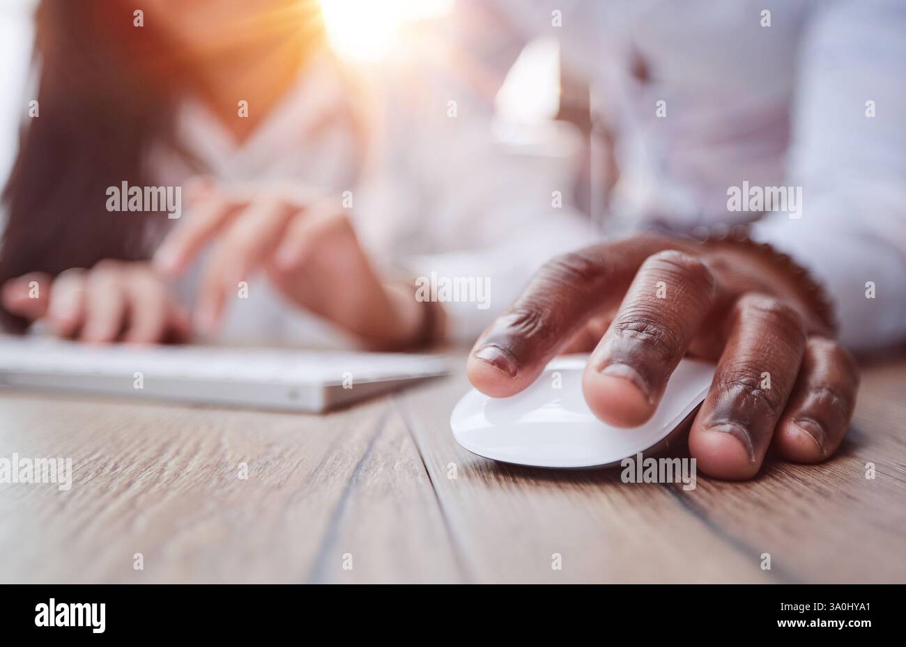 black man holding a computer mouse on the table, close-up Stock Photo