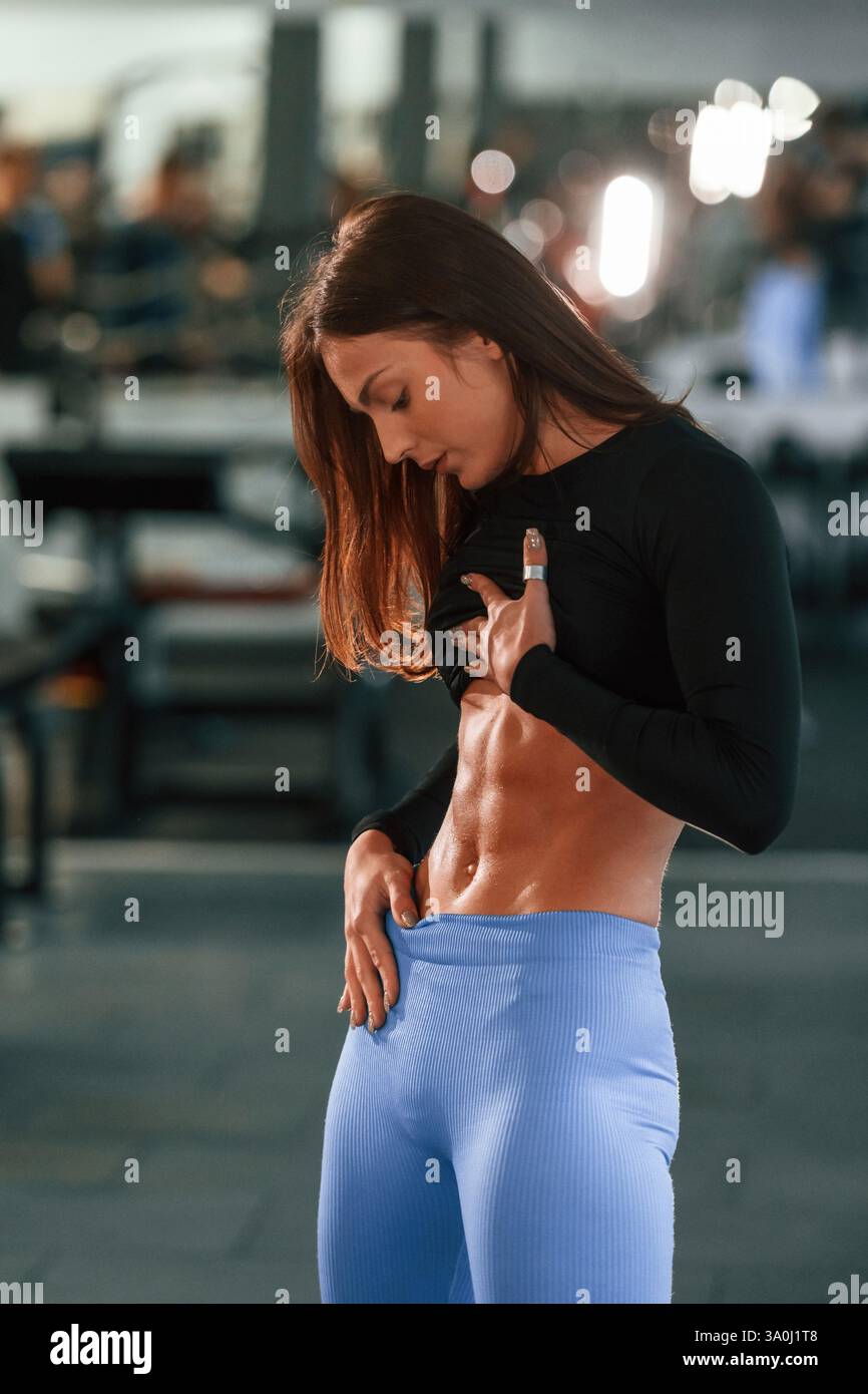Showing abs. Beautiful woman with sport body type is in the gym Stock ...