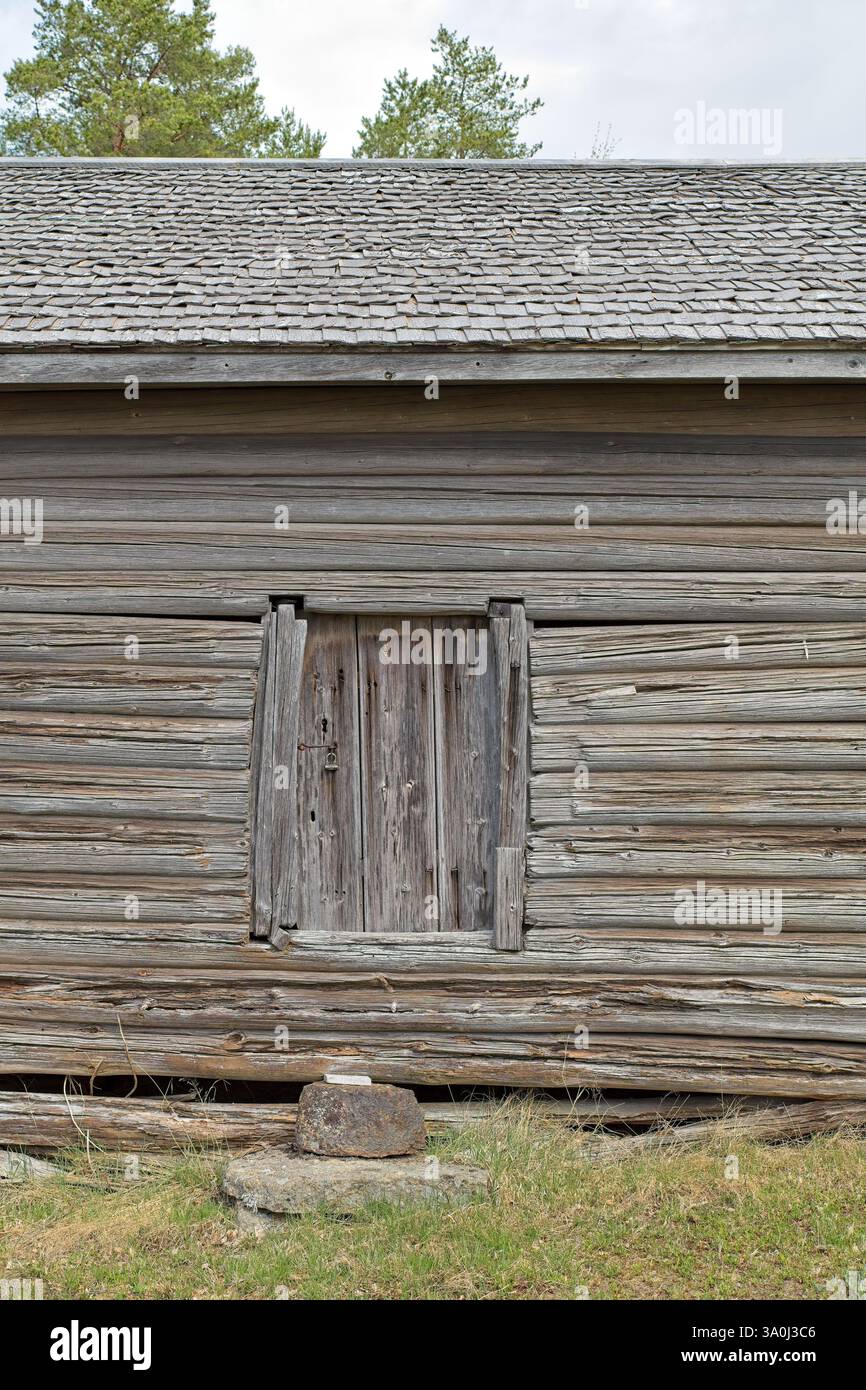 Weathered closed wooden door on an old log building, Finland. Stock Photo