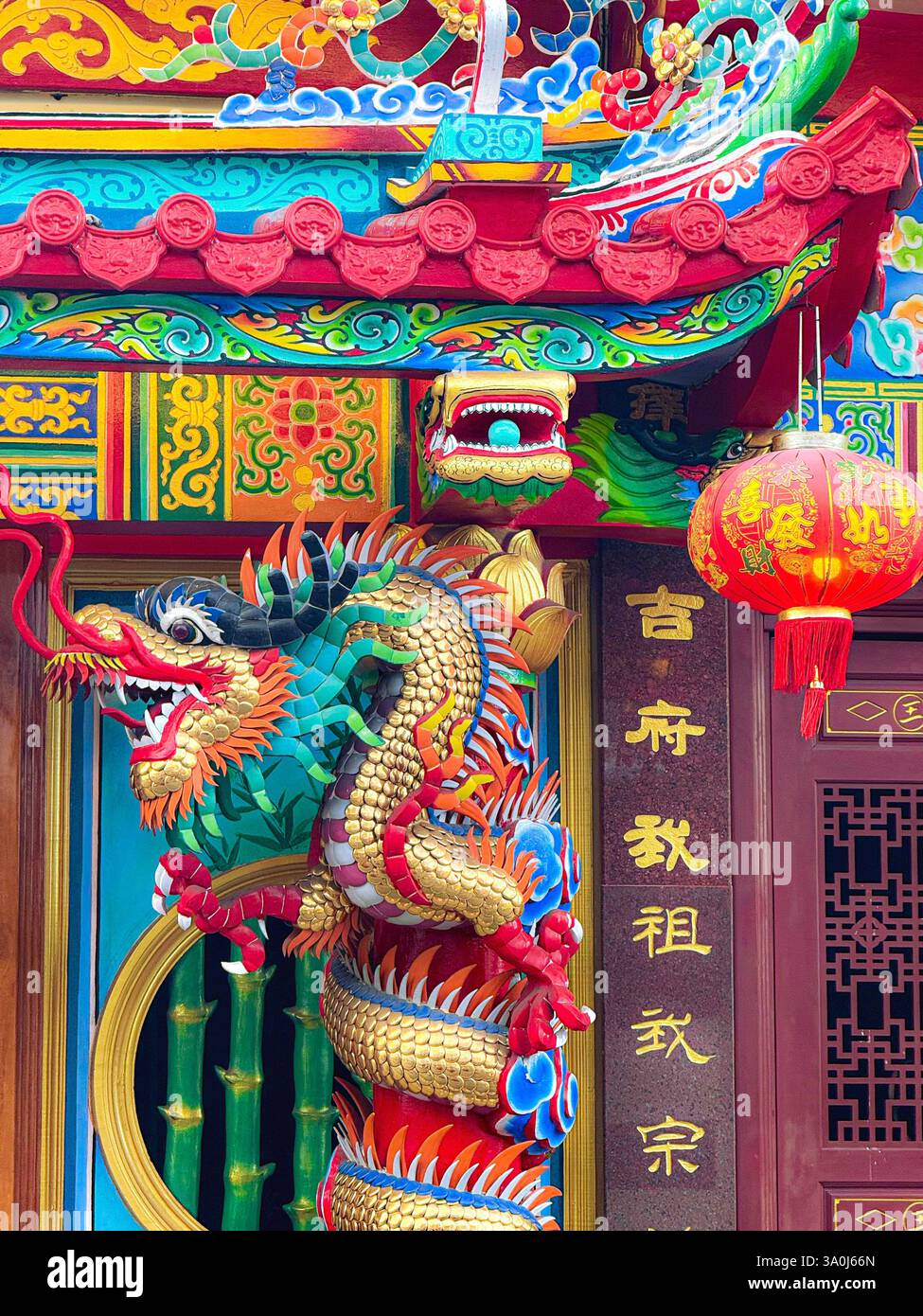 Vibrant Dragon Sculpture on a Chinese Temple Column A detailed and colorful dragon sculpture wrapped around a column in a traditional Chinese temple. Stock Photo