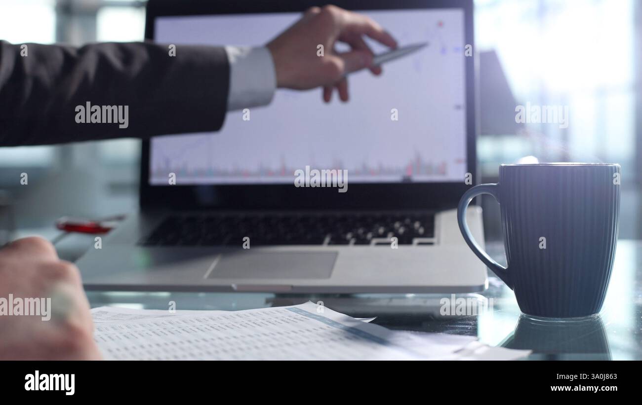 Checking charts on the Internet and documentation Stock Photo