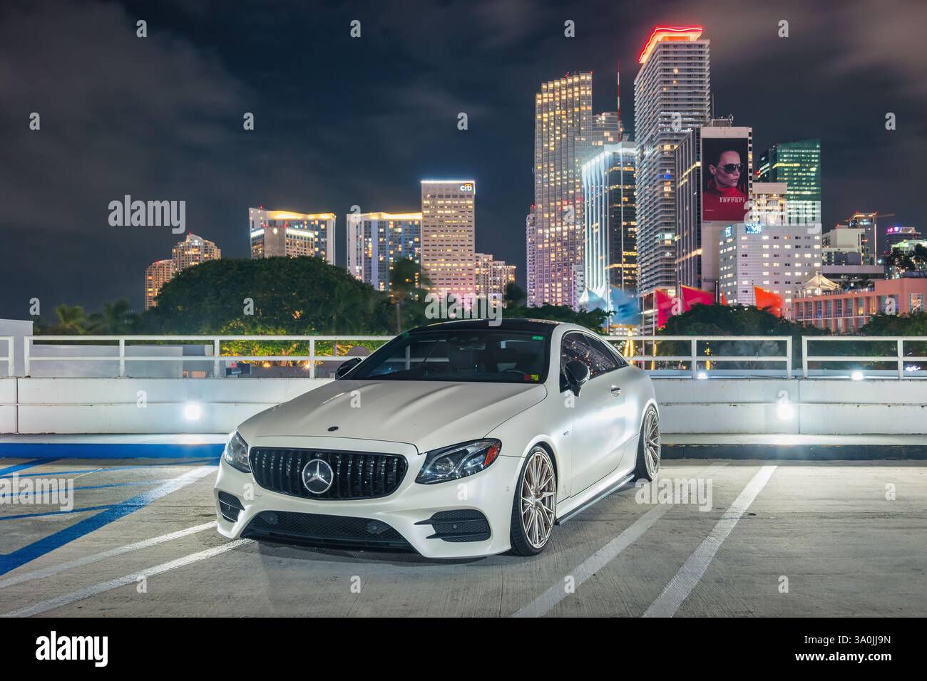 A white colored Mercedes AMG E 53 sports car in downtown Miami, Florida, USA at night. Stock Photo