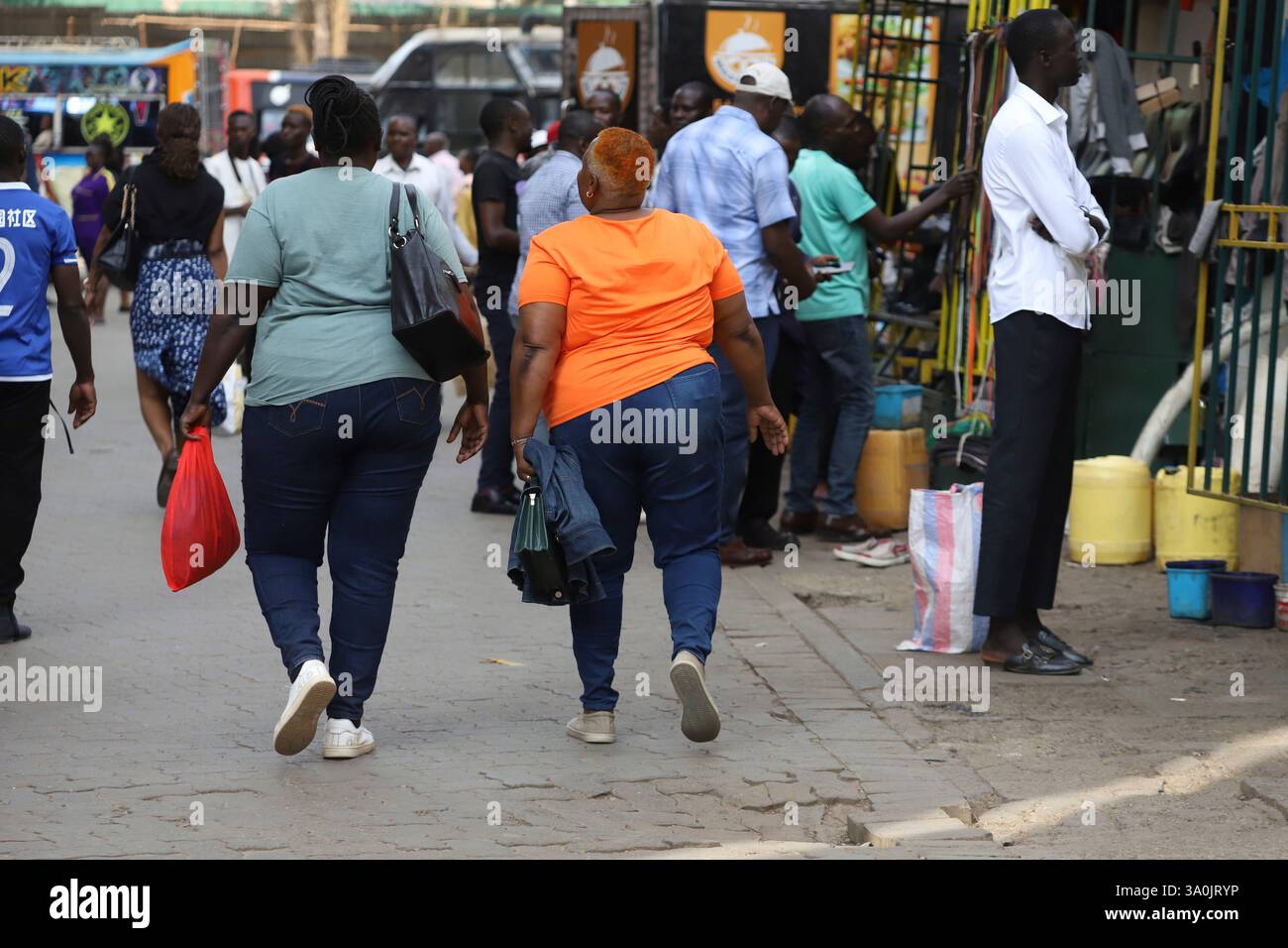 Women walk in the streets of Nairobi, Kenya, during World Obesity Day