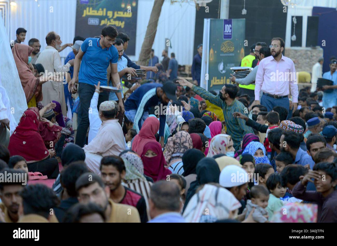 Faithful Muslims are breaking the fast (Iftar) under the supervision of ...