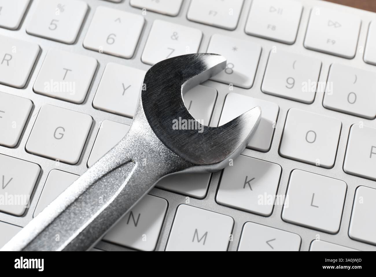 Technical support concept. Wrench on keyboard, closeup Stock Photo