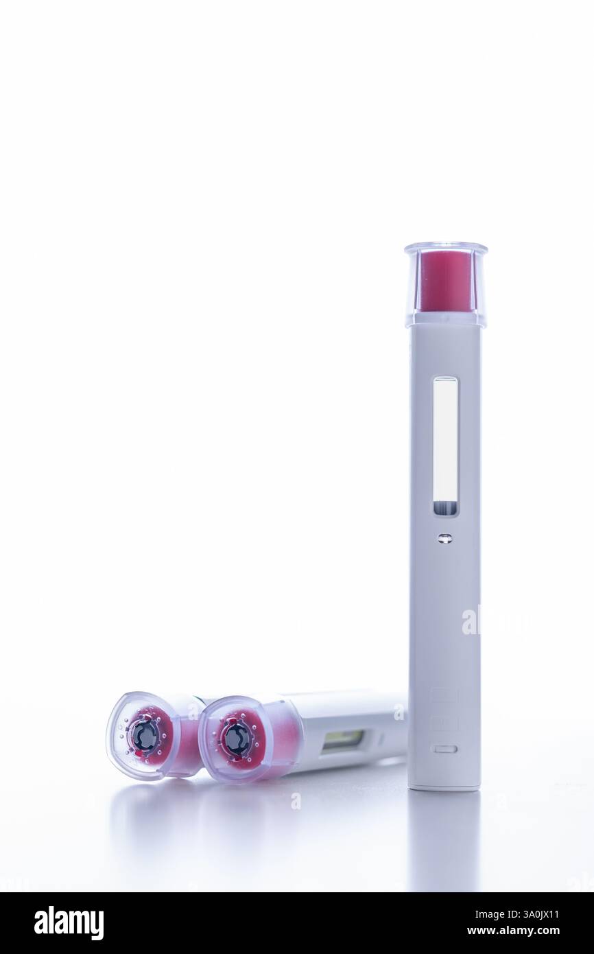 A group of pen injectors with a red tip for biological treatments such ...